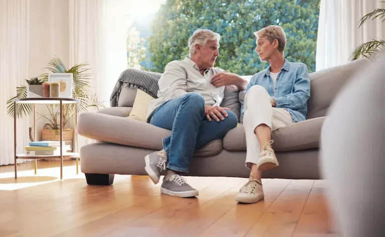 Two spouses on a couch discuss the effects of uncontested divorce on retirement.