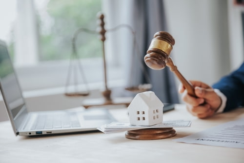 Judge's hammer and toy house representing joint mortgage in an uncontested divorce